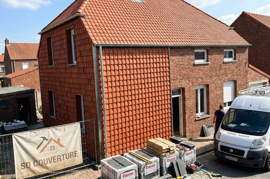 Maison en briques du secteur de Seclin avec toiture et pignon en tuiles neuves, bâche SD Couverture sur la clôture et palettes de tuiles